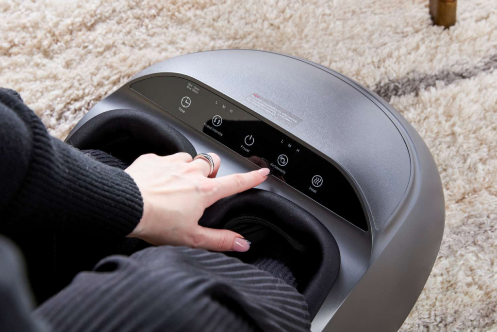 Woman adjusts air intensity settings on a modern grey electronic foot massager.